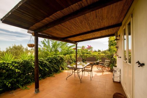 a patio with a wooden pergola with a table and chairs at Casale Bavi in Ortona