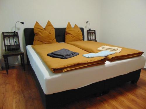 Una cama con almohadas naranjas y mantas. en FerienAppartement NO.18, en Sangerhausen