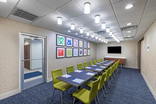 a conference room with a long table and yellow chairs at Holiday Inn Express & Suites Purcell by IHG in Purcell