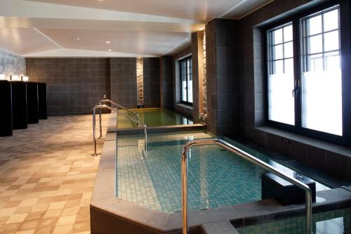 a bath room with a swimming pool in a building at Hotel Monterey Okinawa Spa & Resort in Onna