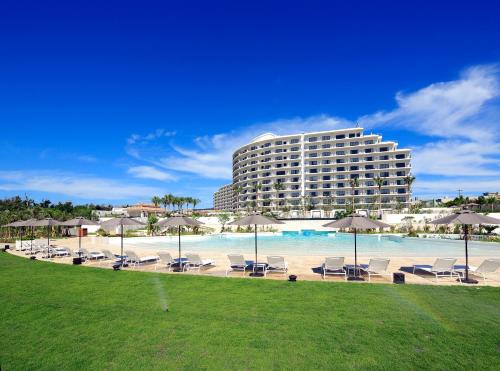 恩納村にあるホテルモントレ沖縄　スパ＆リゾートのホテルには椅子とパラソルとプールがあります。