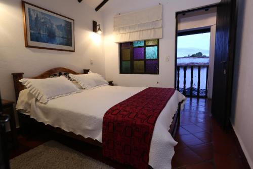 a bedroom with a bed and a balcony at Hotel Don Paulino in Villa de Leyva