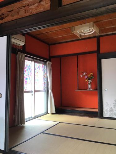 a room with red walls and a window at Airport Osaka in Kaizuka
