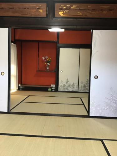 a room with sliding glass doors and a vase of flowers at Airport Osaka in Kaizuka