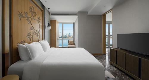 a hotel room with a bed and a flat screen tv at InterContinental Haikou Seaview by IHG in Haikou