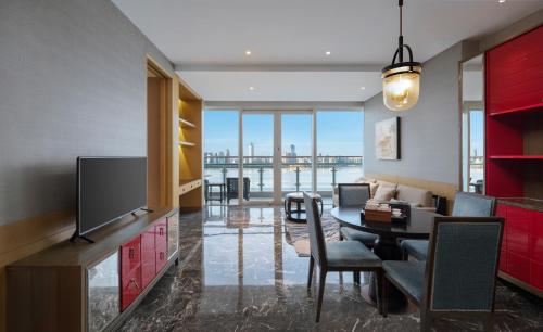 uma sala de estar com uma televisão e uma mesa de jantar em InterContinental Haikou Seaview, an IHG Hotel em Haikou