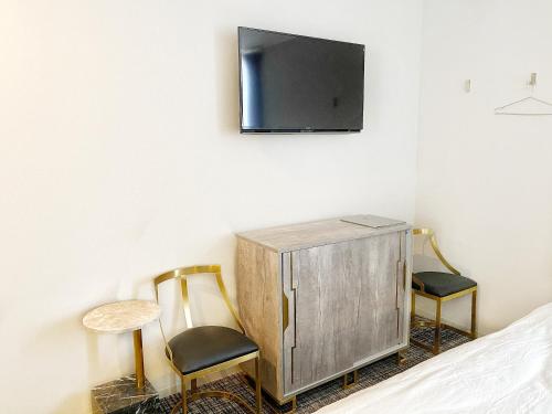 una camera da letto con due sedie e una TV a parete di The Barn Tokyo a Tokyo
