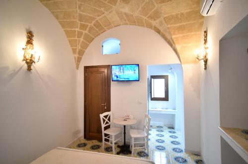 a room with a table and chairs and a door at B&B Corte Casole in Gallipoli
