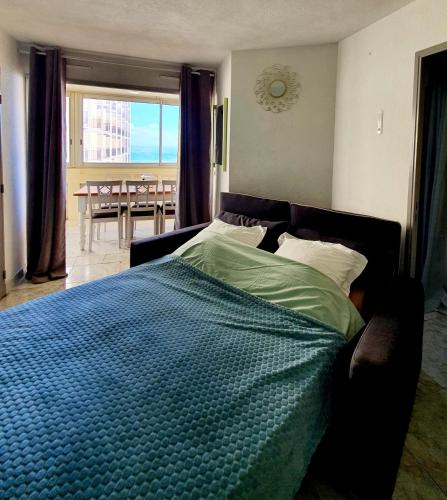 une chambre avec un lit avec une couette bleue dans l'établissement Superbe appartement face à la mer avec parking privatif, à Canet