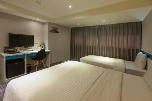 ein Hotelzimmer mit einem Bett und einem Schreibtisch in der Unterkunft 9ine Hotel in Taipeh