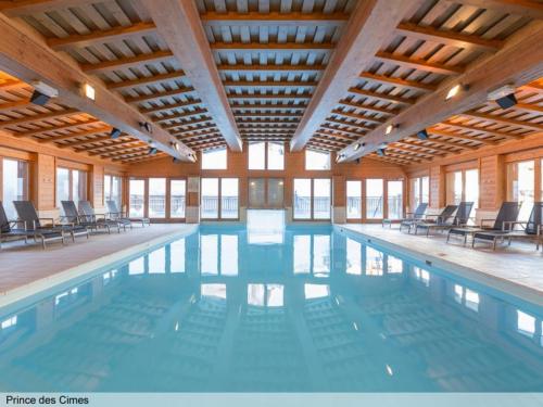 una gran piscina con sillas en un edificio en Le Prince Des Cimes en Arc 1950