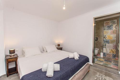 a bedroom with a white bed with towels on it at Peristeronas Village in Klouvas