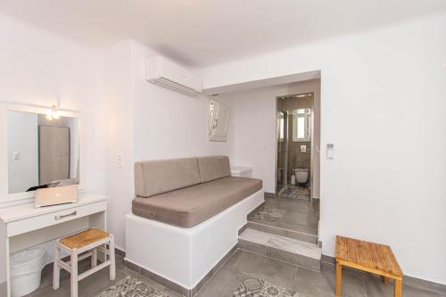 a room with a couch and a desk and a mirror at Peristeronas Village in Klouvas