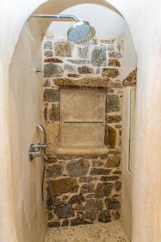 a bathroom with a shower in a stone wall at Peristeronas Village in Klouvas