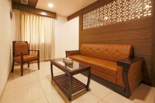 a living room with a couch and a table at Aloka Stay Inn in Vellore