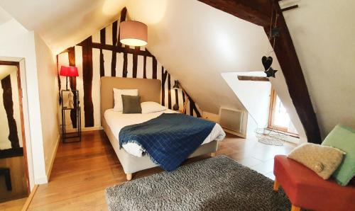 a bedroom with a bed and a staircase with a chair at ArT Home Maison d'artiste in Honfleur