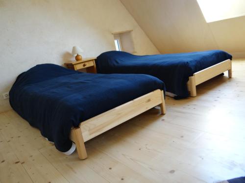 two beds with blue sheets in a room at La Fermette de TREGASTEL, classée 3 étoiles in Trégastel