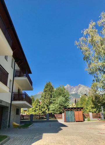 a view of a building with mountains in the background at Apartmán FRANZ in Tatranská Lomnica