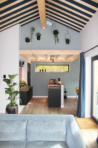a living room with a couch and a table at Hoeve Altena Cottage in Woudrichem