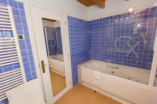 a blue tiled bathroom with a tub and a sink at Hotel Rural Casa Xusto in La Caridad