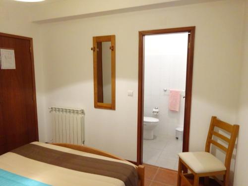 a bedroom with a bed and a bathroom with a toilet at Hospedaria Lampião in Penacova