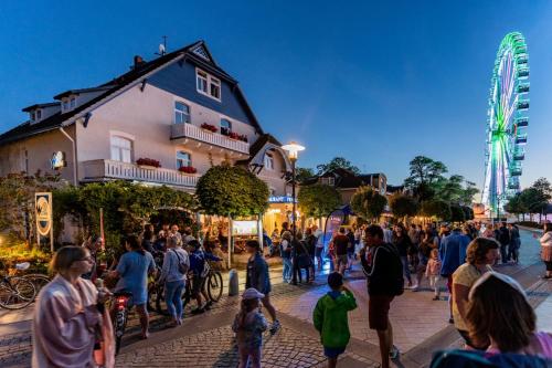 a crowd of people walking down a street at night at Strandhaus WOTAN in Kühlungsborn