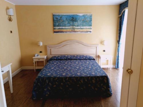 a bedroom with a bed with a blue comforter at Hotel Columbus in Lignano Sabbiadoro