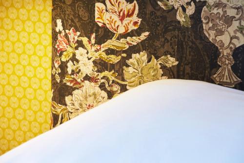 a room with a wall with a floral wallpaper at Hôtel Vaubecour - Centre Lyon Ainay - Perrache in Lyon