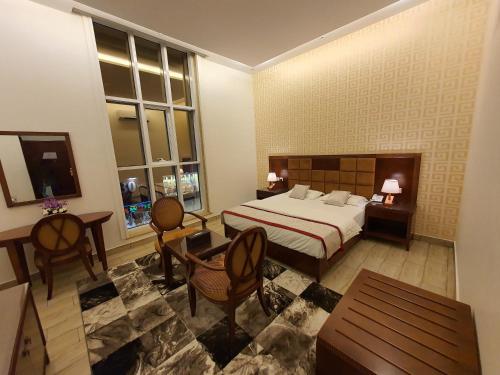 um quarto com uma cama, uma mesa e cadeiras em فندق درة الرؤية em Jidá