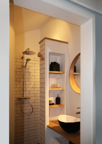 a bathroom with a sink and a shower at Hoeve Altena Cottage in Woudrichem