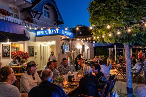 a group of people sitting at a restaurant at night at Strandhaus WOTAN in Kühlungsborn