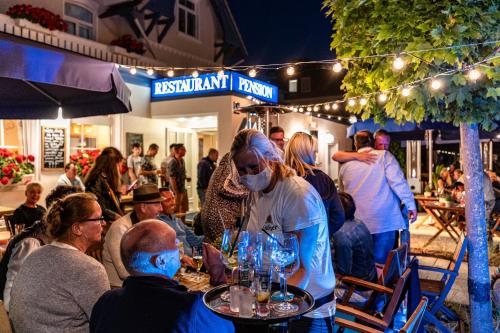 a group of people sitting at a table in a restaurant at Strandhaus WOTAN in Kühlungsborn