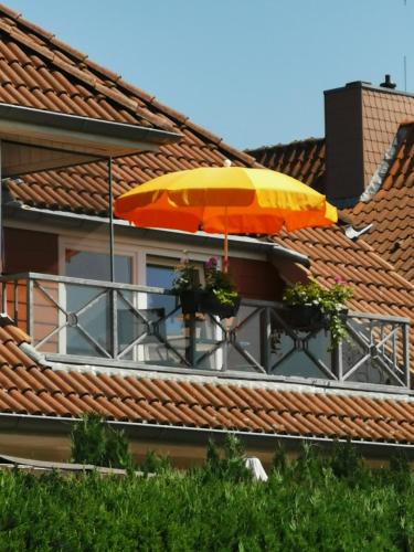einen Balkon mit einem Sonnenschirm auf einem Gebäude in der Unterkunft Ferienwohnung "Zur Biene" in Winsen