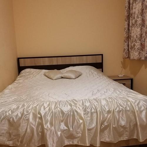 a bed with two pillows on top of it at Смарт-апартаменти " Lutskyj zamok" in Luts'k