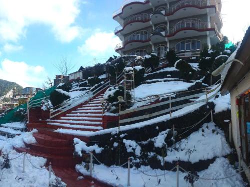a building with snow covered stairs in front of it at Hotel Victoriya Palace,Mcleod Ganj in McLeod Ganj