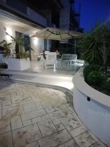 a patio with chairs and an umbrella at night at A casa di cinzia in Pineto