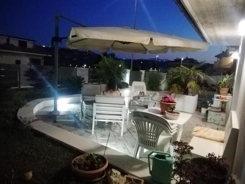 a patio with a table and chairs and an umbrella at A casa di cinzia in Pineto