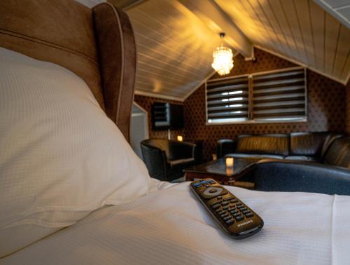 un telecomando posto sopra un letto di HOTELLMILANO AS a Mosjøen