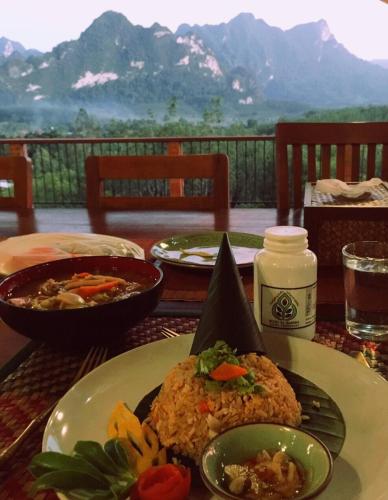 a table with a plate of food on a table at Billion Views Khaosok Homestay in Khao Sok
