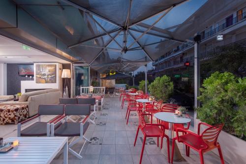 a patio with tables and chairs and a couch at Habitat Hotel in Kilkís