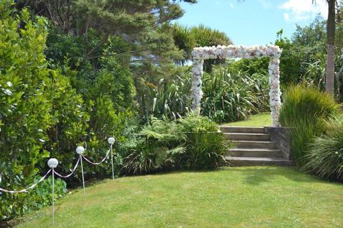 an arch with flowers on it in a garden at The Waiheke Lodge in Onetangi