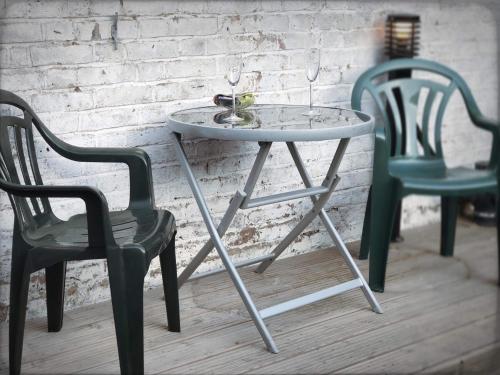 a table and two chairs next to a brick wall at Richmond Luxury flat Fabulous location in Southend-on-Sea