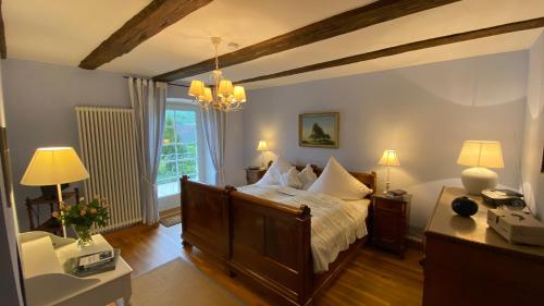 a bedroom with a bed and a table with lamps at Gutshof Güntert - ehemaliges Weingut von 1741 in Sulzburg