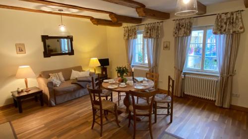 a living room with a table and chairs and a couch at Gutshof Güntert - ehemaliges Weingut von 1741 in Sulzburg