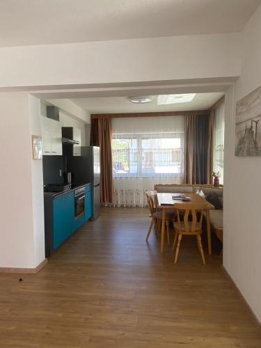 a kitchen and living room with a table and a dining room at Pension Alpina in Roppen