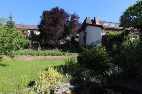 a garden with trees and a building in the background at Villa-Fuldablick in Morschen