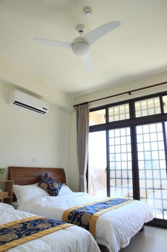 a bedroom with three beds and a large window at Ancient Official Road Homestay in Jinhu