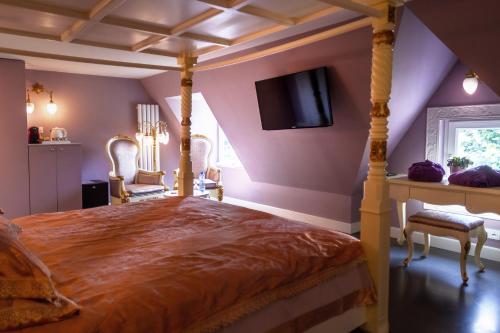 a bedroom with a bed and a television at B&B Saint-Georges in Bruges