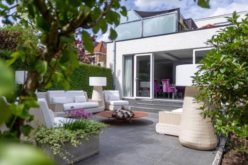 a patio with white furniture and a house at B&B Saint-Georges -Located in the city centre of Bruges- in Bruges