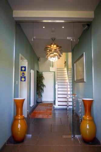 a hallway with two orange vases in a hallway at B&B Saint-Georges -Located in the city centre of Bruges- in Bruges